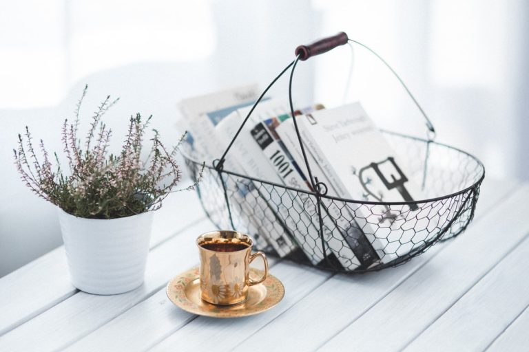 a wire woven basket with black and white books inside