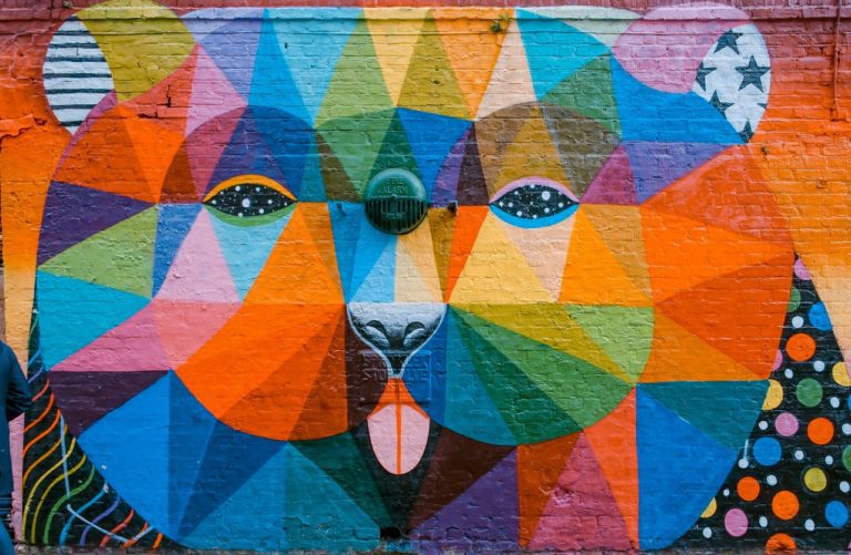 a mural on a brick wall of an animal in an aztec colourful print