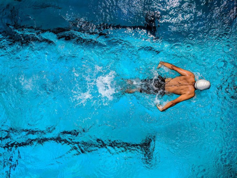 a man swimming in a pool, aerial view