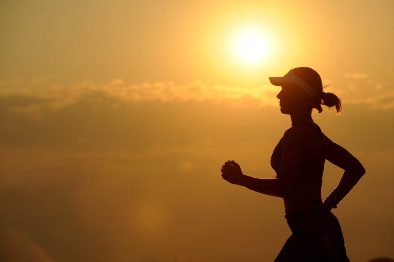 silhouette of a woman running against a sunset